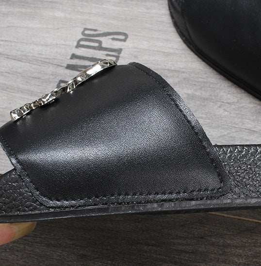 Close-up of a black leather wallet with a zipper on a gray surface.