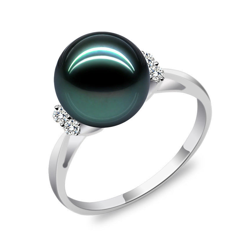 Ring with a large black pearl and smaller pearls on a white background