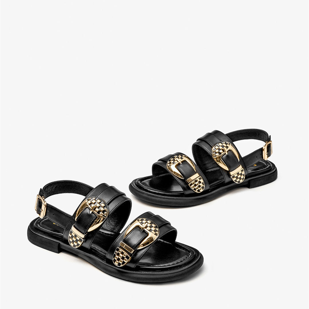 Black sandals with gold buckles on a white background