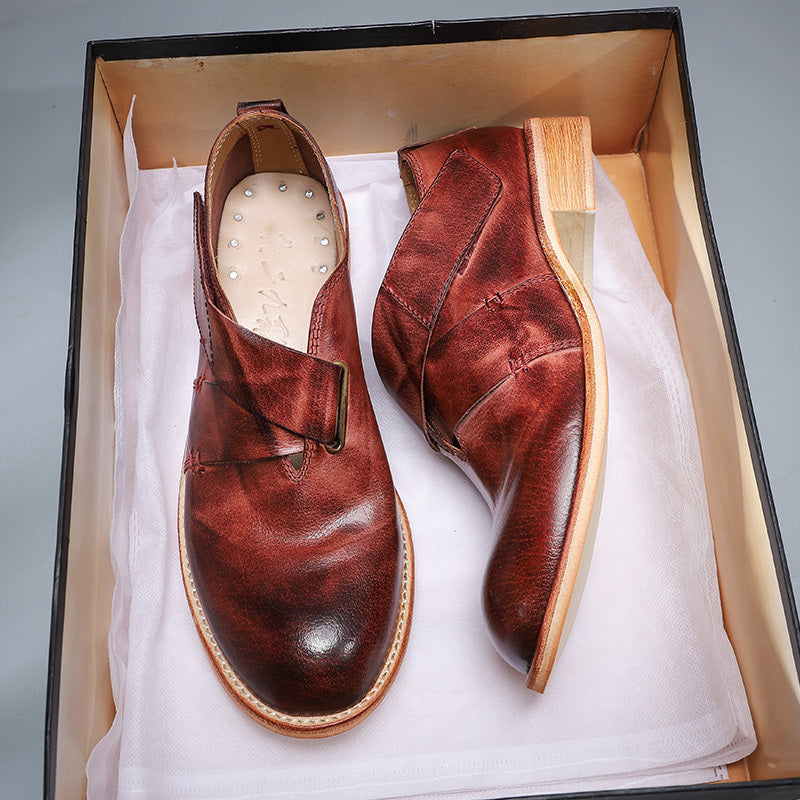 Pair of brown leather shoes in a box with white tissue paper