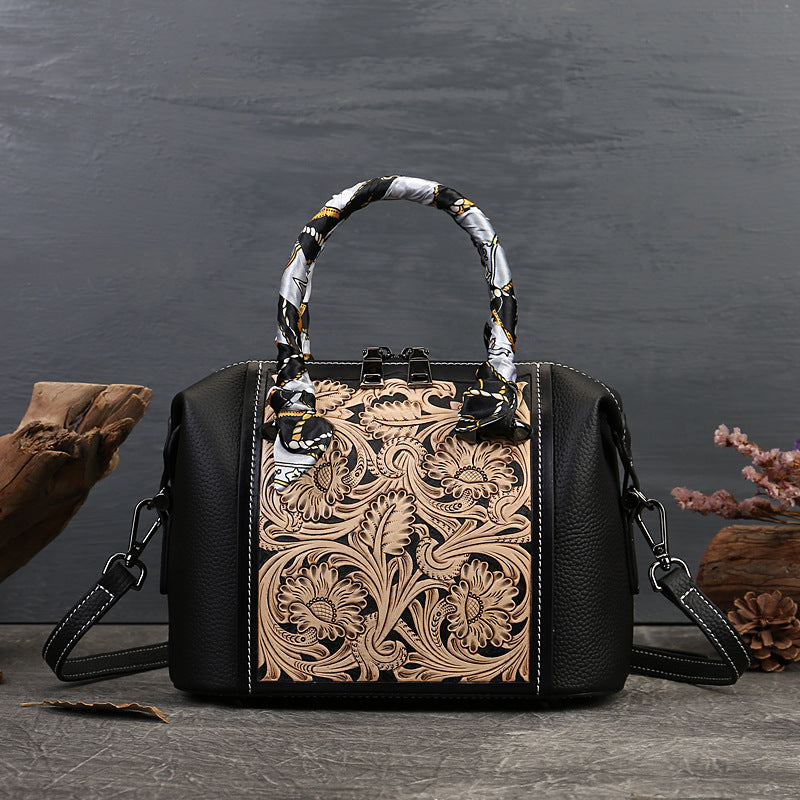 Black handbag with intricate leather design on a dark background