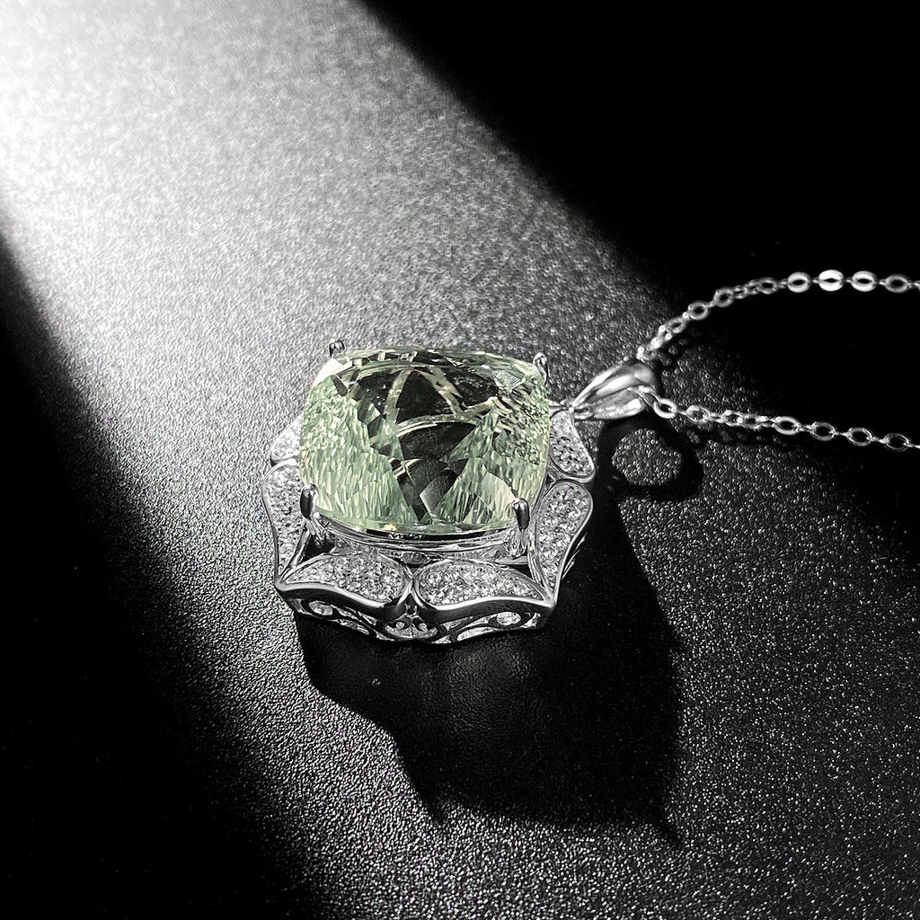 Green gemstone pendant on a chain against a dark background