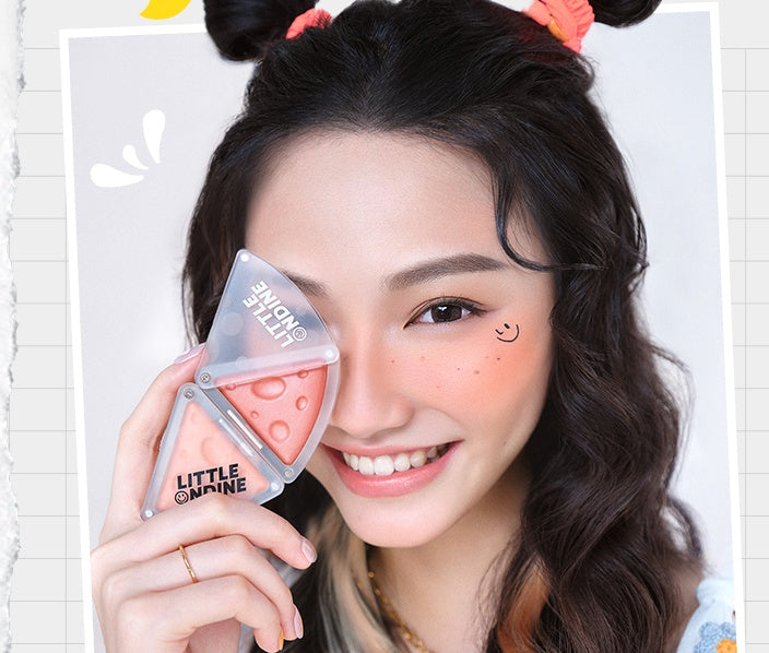 Woman holding a makeup product with a smile on her face