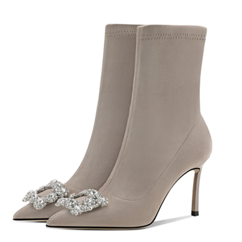 Beige high-heeled boots with decorative bow on a white background