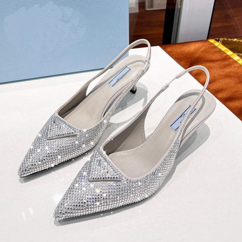 Silver studded high heels on a white surface with a blurred background
