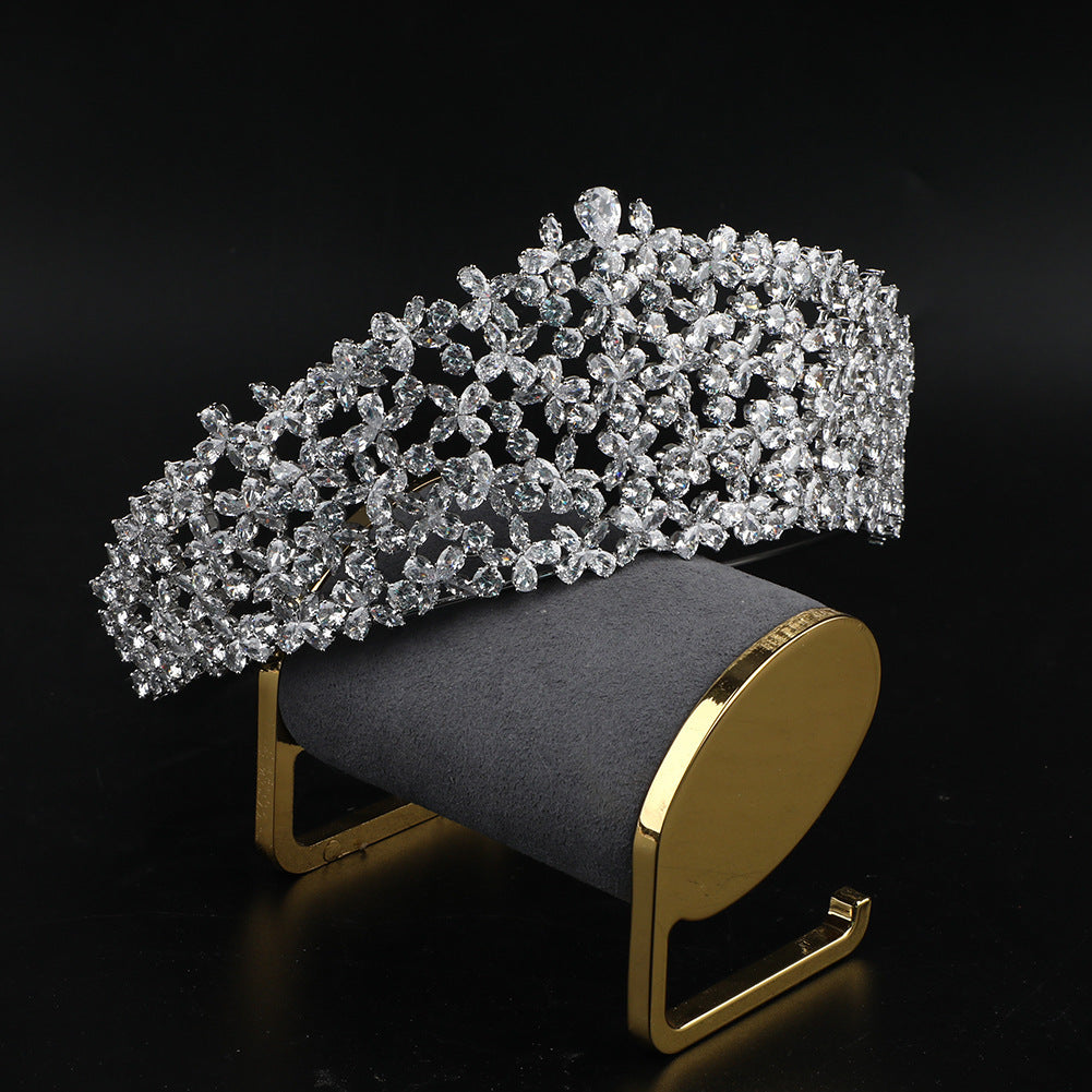 Diamond tiara on a black and gold display stand against a black background