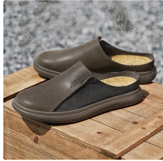 Brown slip-on shoes with cork insoles on a wooden surface with a stone background