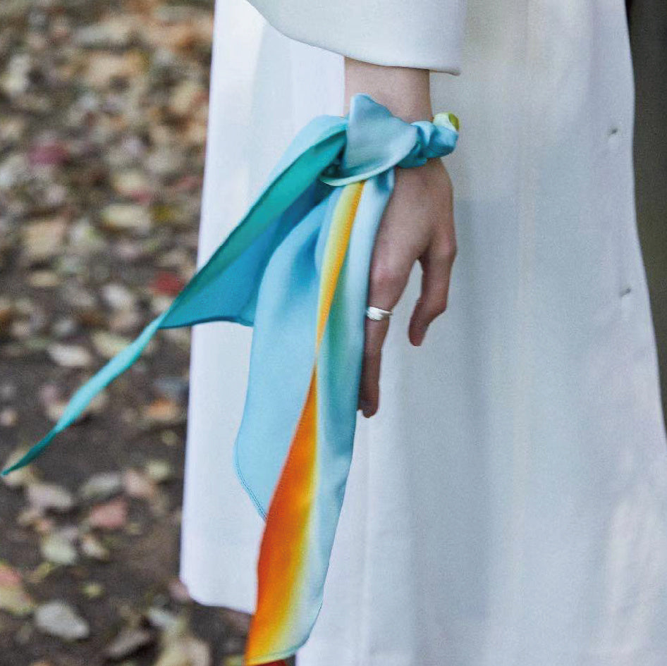 Person wearing a colorful scarf with a blurred natural background