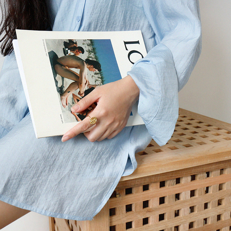 Person holding a magazine with a blurred cover on a wooden surface