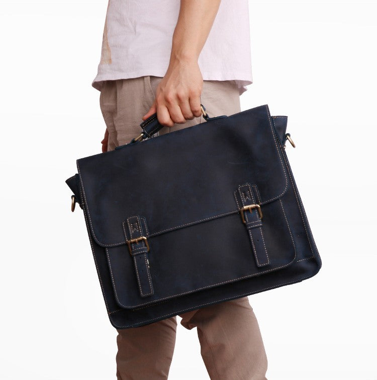 Person holding a navy blue leather briefcase on a white background