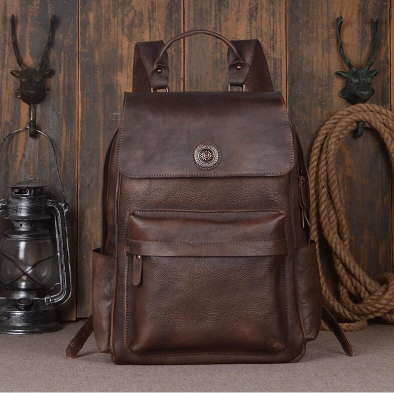 Brown leather backpack on a wooden background with rustic decor elements.