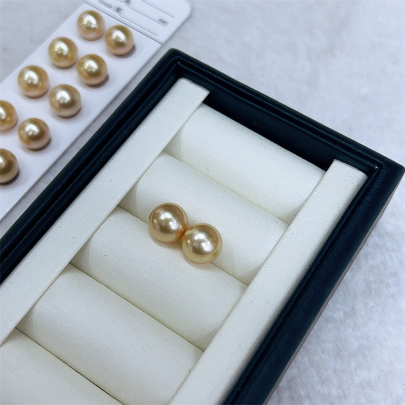 Pearl earrings in a jewelry box with pearls on a white background