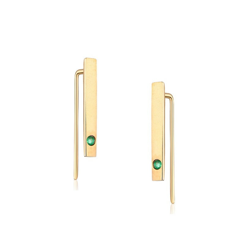Gold earrings with green gemstones on a white background