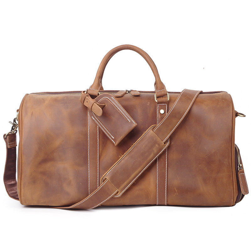Brown leather duffel bag with shoulder strap on a white background