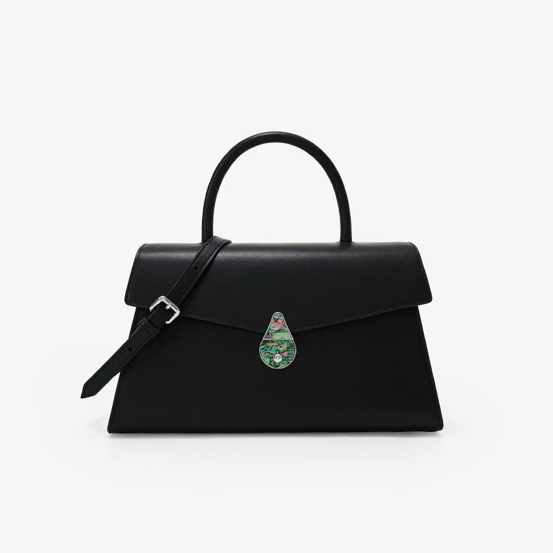 Black handbag with a decorative clasp on a white background