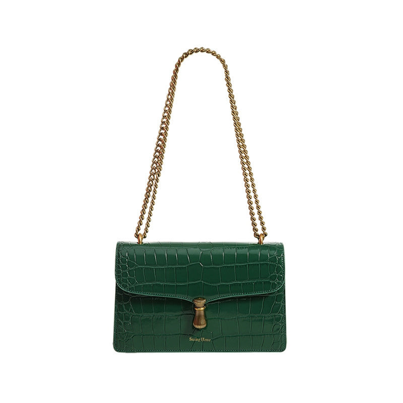 Green crocodile-patterned handbag with a gold chain strap on a white background