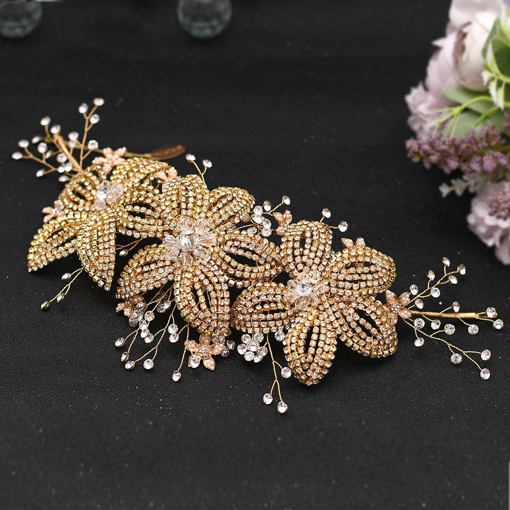 Decorative hair piece with gold leaves and crystals on a black background