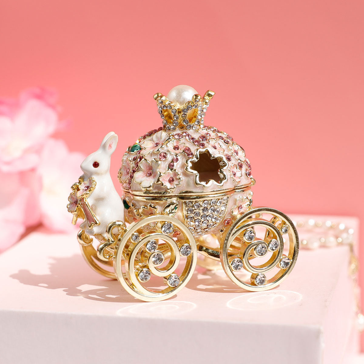 Decorative car-shaped box with intricate details on a pink background