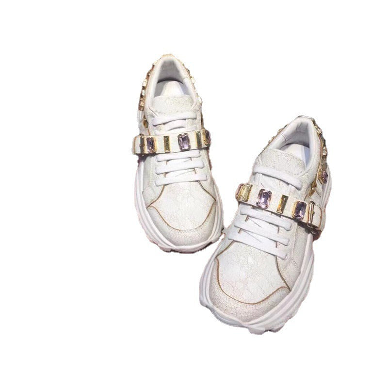 White sneakers with gold and purple embellishments on a white background