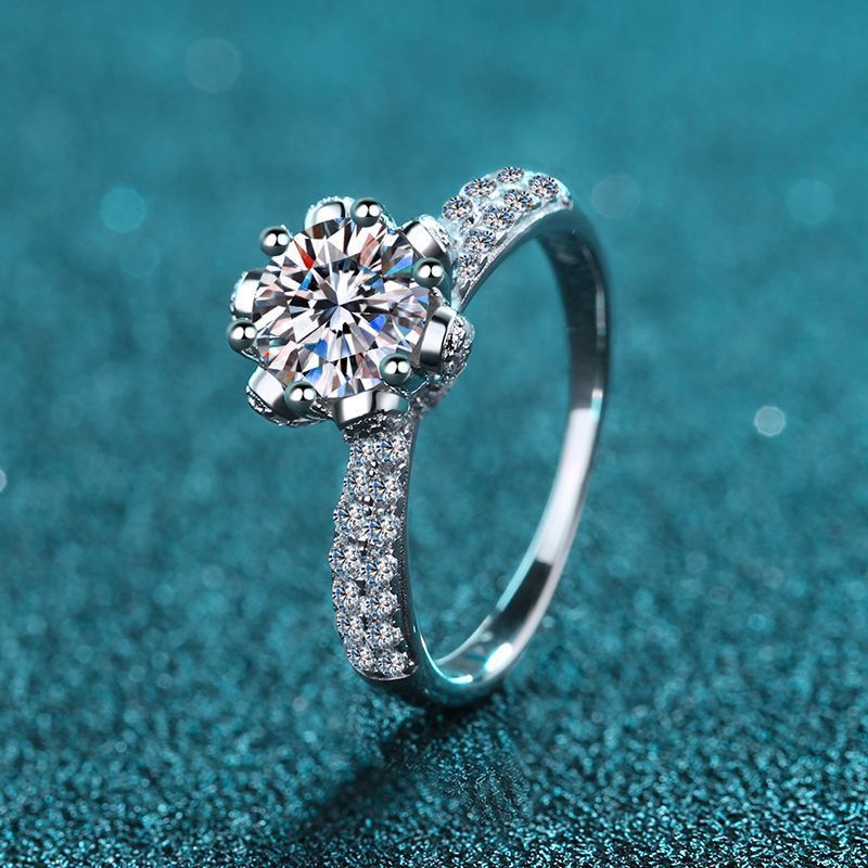 Silver ring with a large diamond on a blue textured background