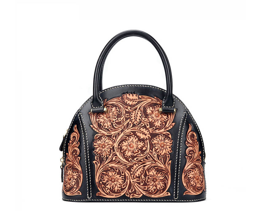 Black handbag with intricate brown leather patterns on a white background