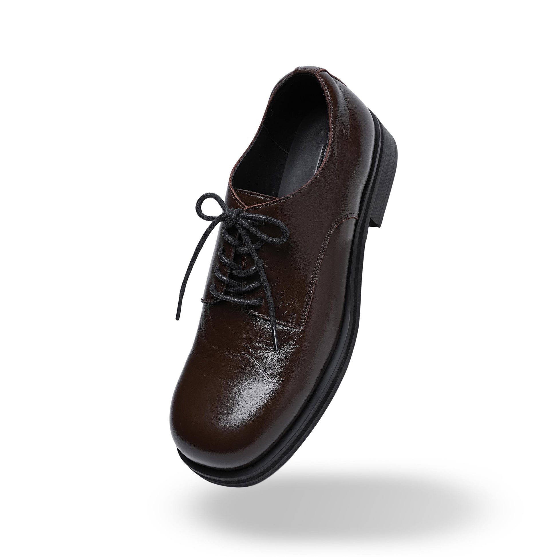 Brown leather shoe with black laces on a white background
