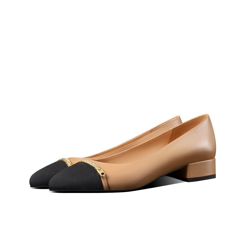 Pair of beige and black shoes with gold accents on a white background