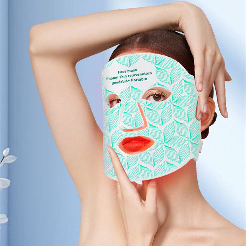 Person wearing a green face mask with a leaf pattern on a blue background