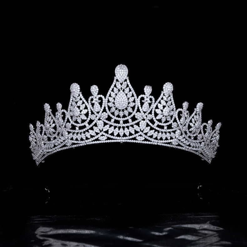 Silver tiara with intricate design on a black background