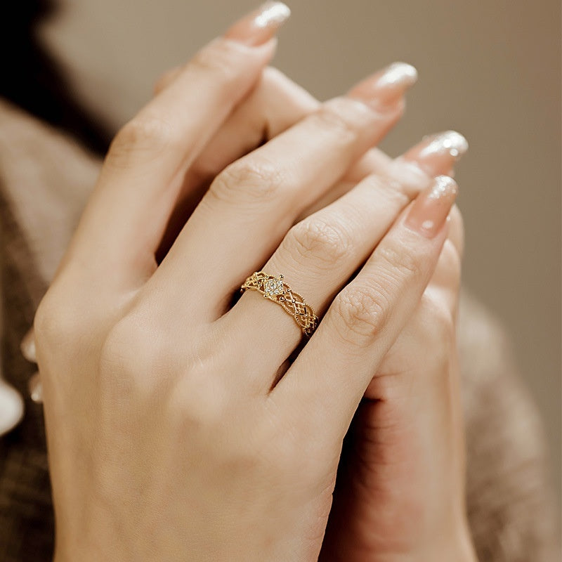 Close-up of a hand wearing a gold ring with a blurred background