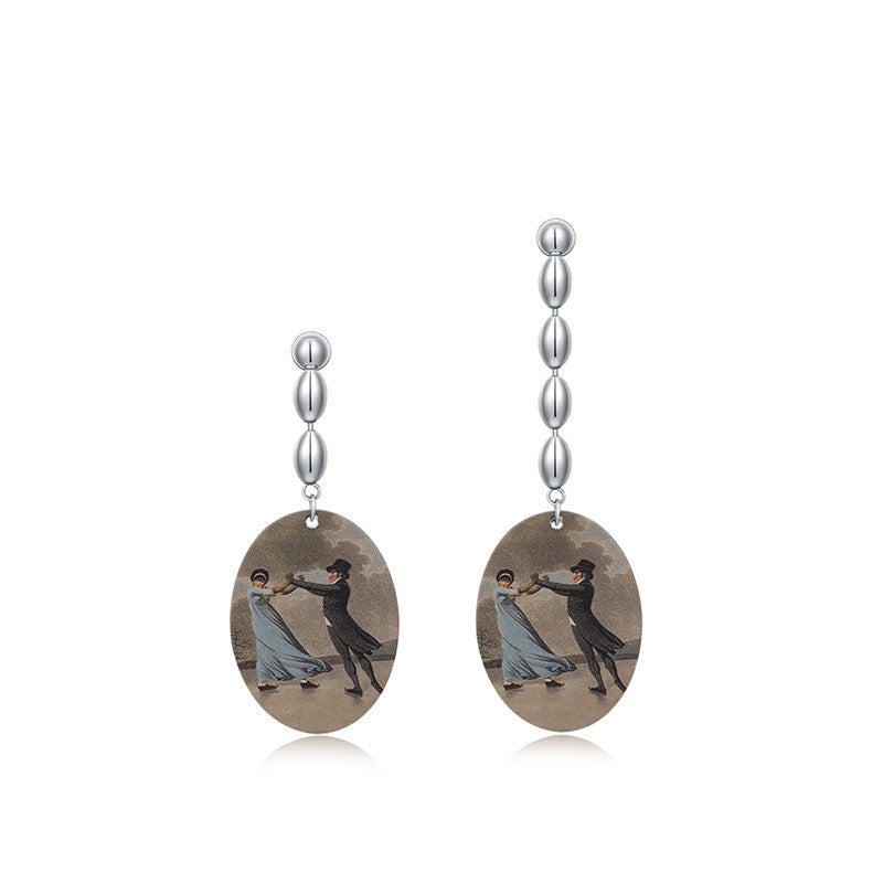 Pair of earrings with oval-shaped discs featuring dancing couples on a white background