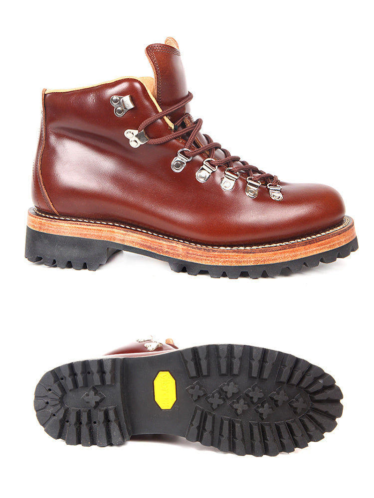 Brown leather boot with orange sole on a white background