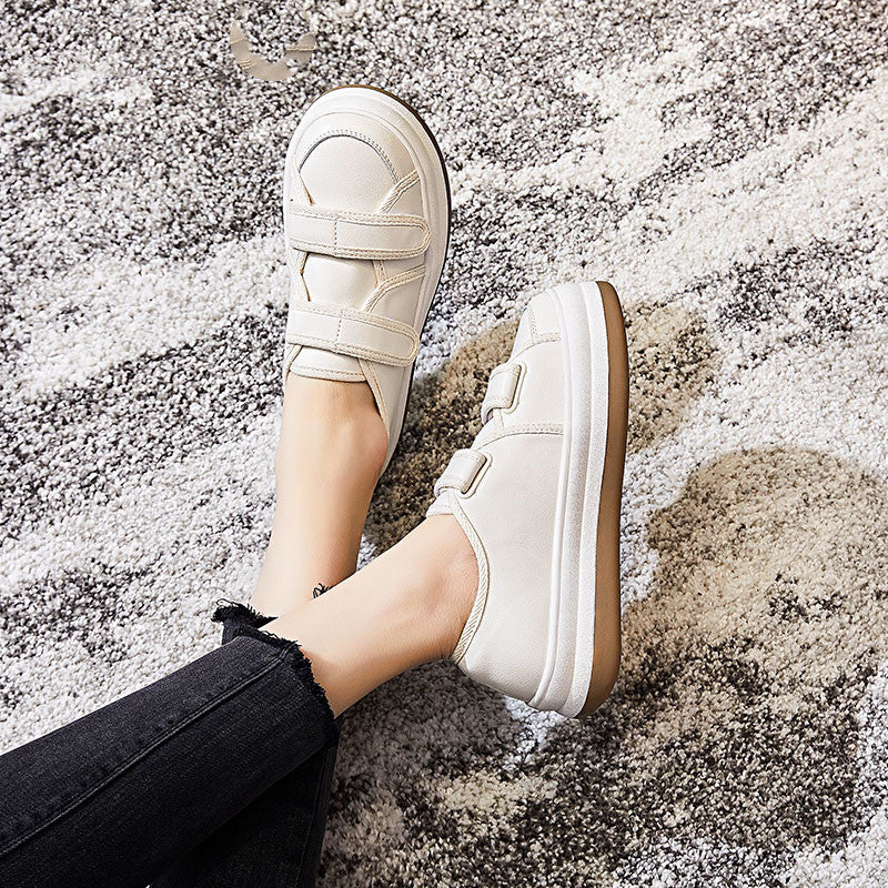 White sneakers worn on a textured surface