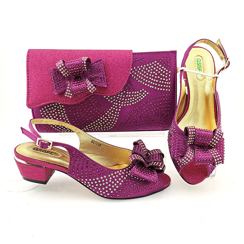 Purple shoes and matching handbag with decorative bow and crystals on a white background