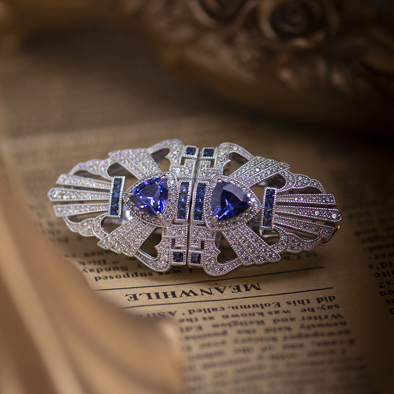 Decorative brooch with blue gemstones on an open book