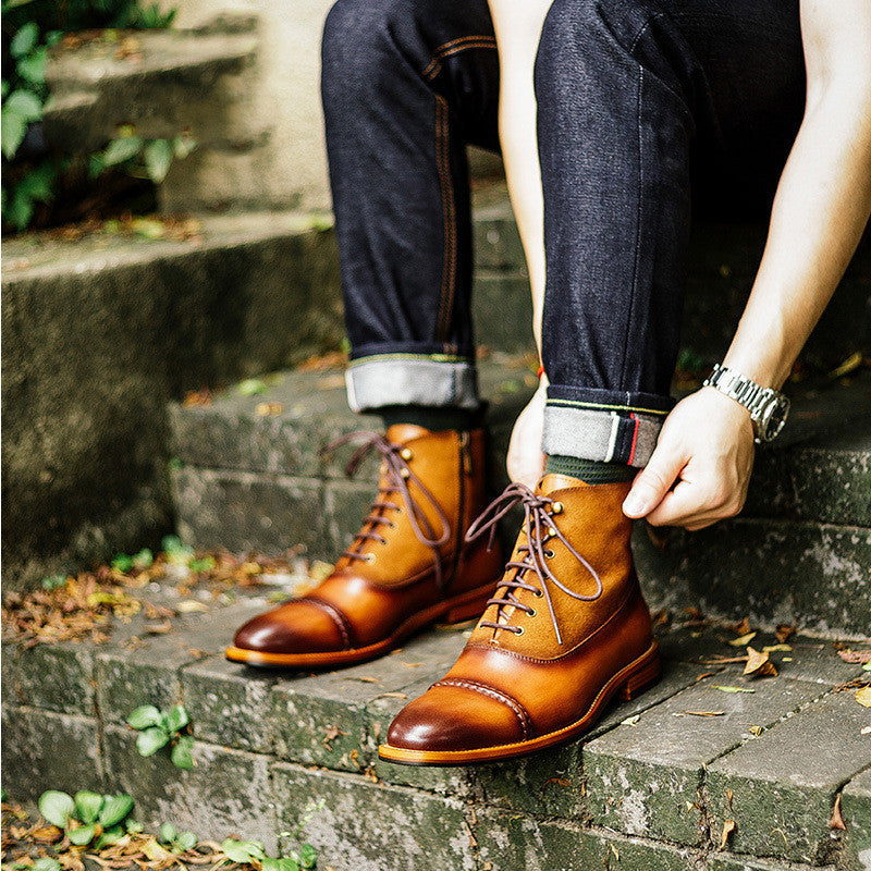 Person wearing brown leather shoes sitting on stone steps.
