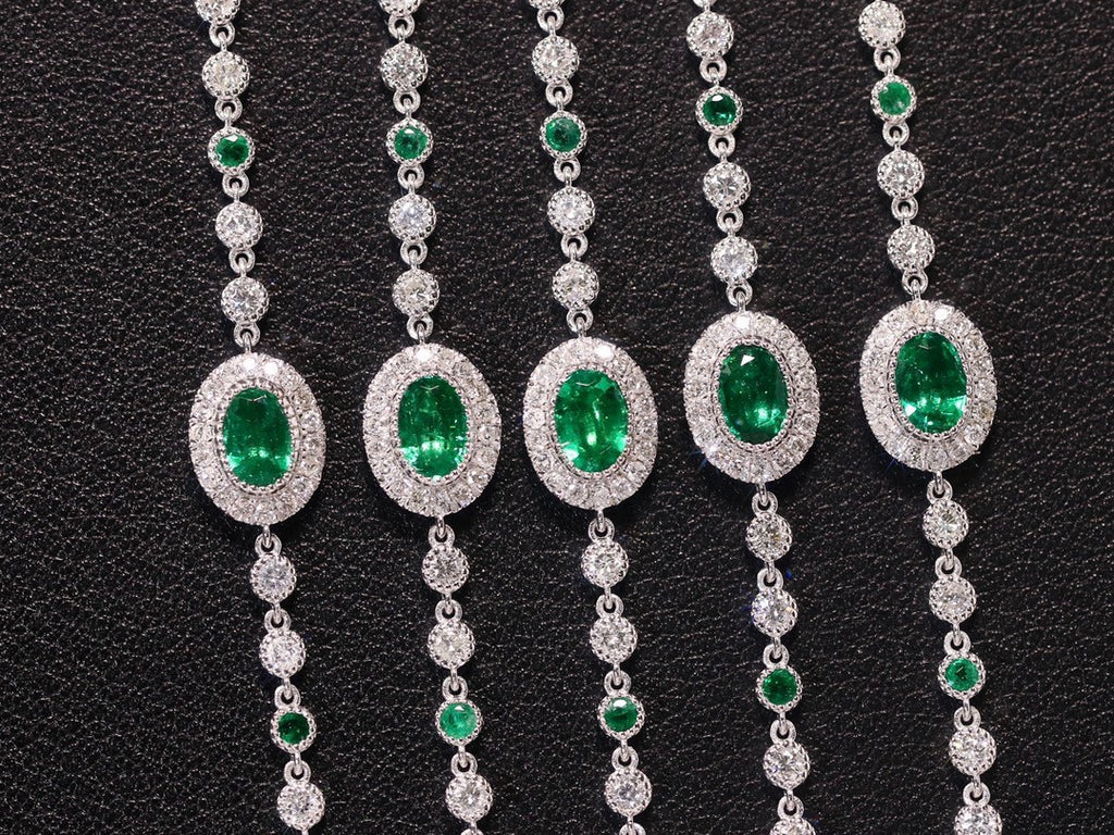 Set of diamond and emerald necklaces on a black background