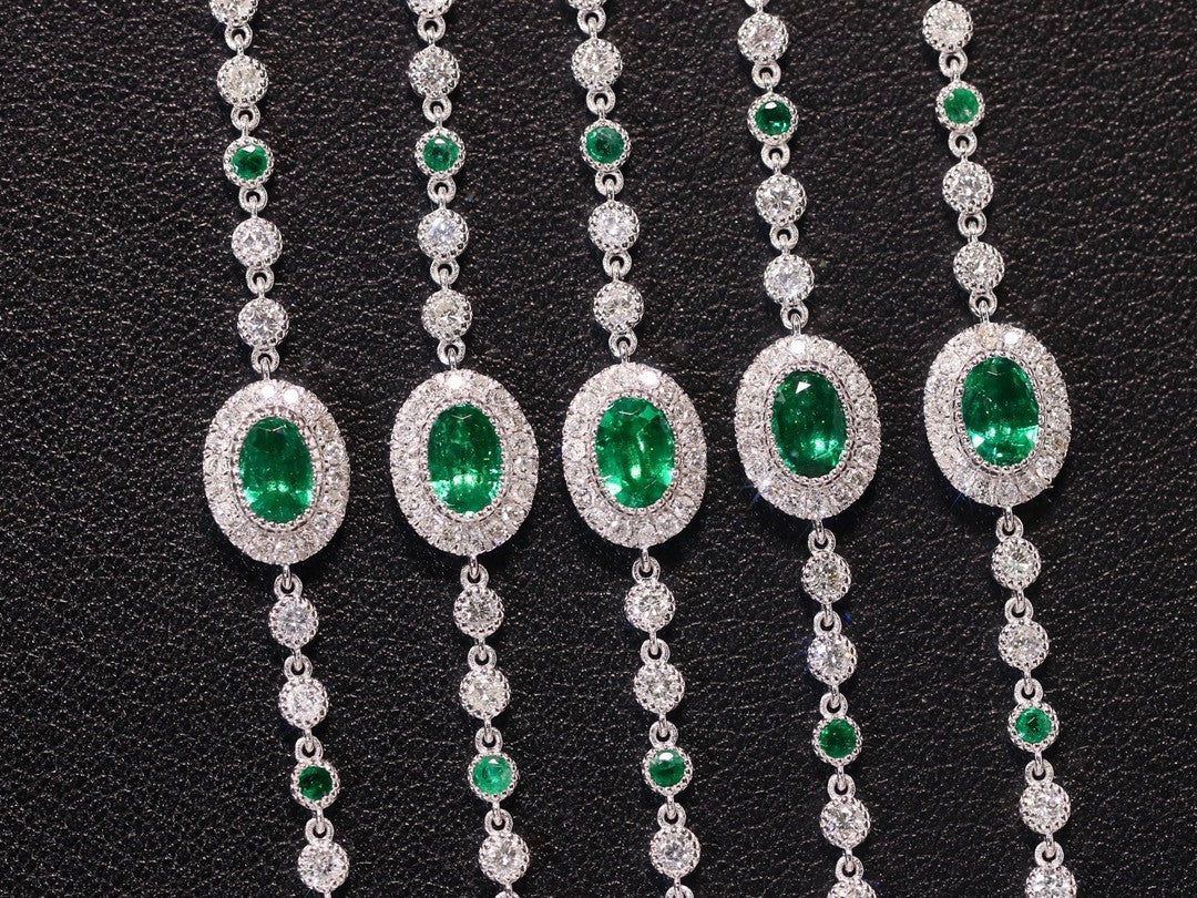 Set of diamond and emerald necklaces on a black background