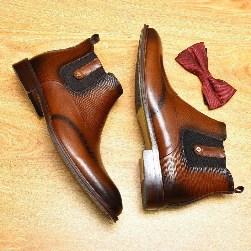 Pair of brown leather boots with a red bow tie on a wooden surface