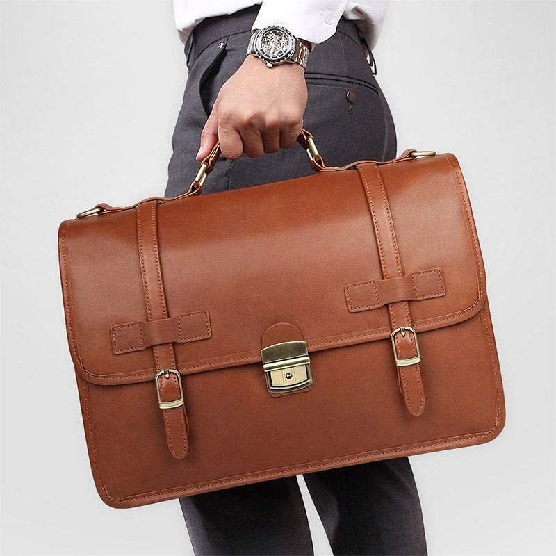 Brown leather briefcase held by a person against a plain background