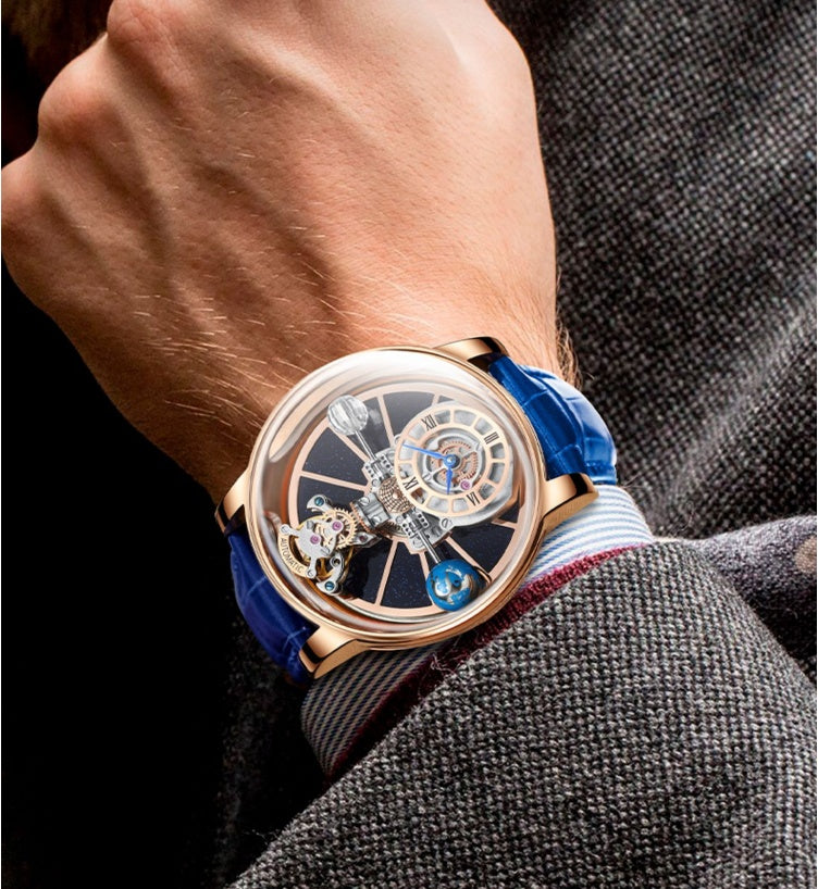 Luxury watch with a blue strap on a person's wrist, wearing a gray suit.