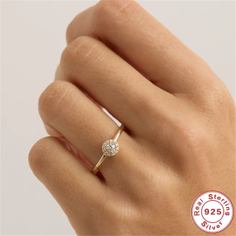 Gold ring with diamond on a hand, featuring a 'Real Sterling Silver 925' stamp.