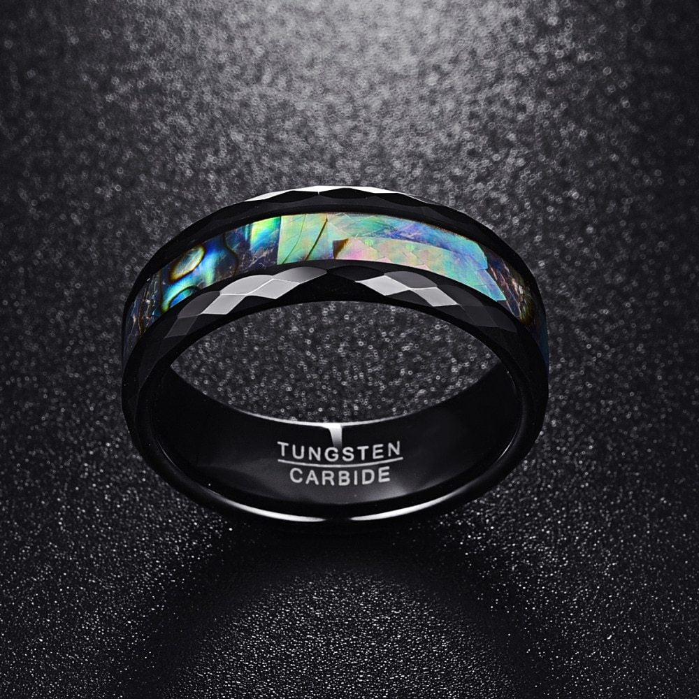 Black tungsten carbide ring with colorful interior on a dark background