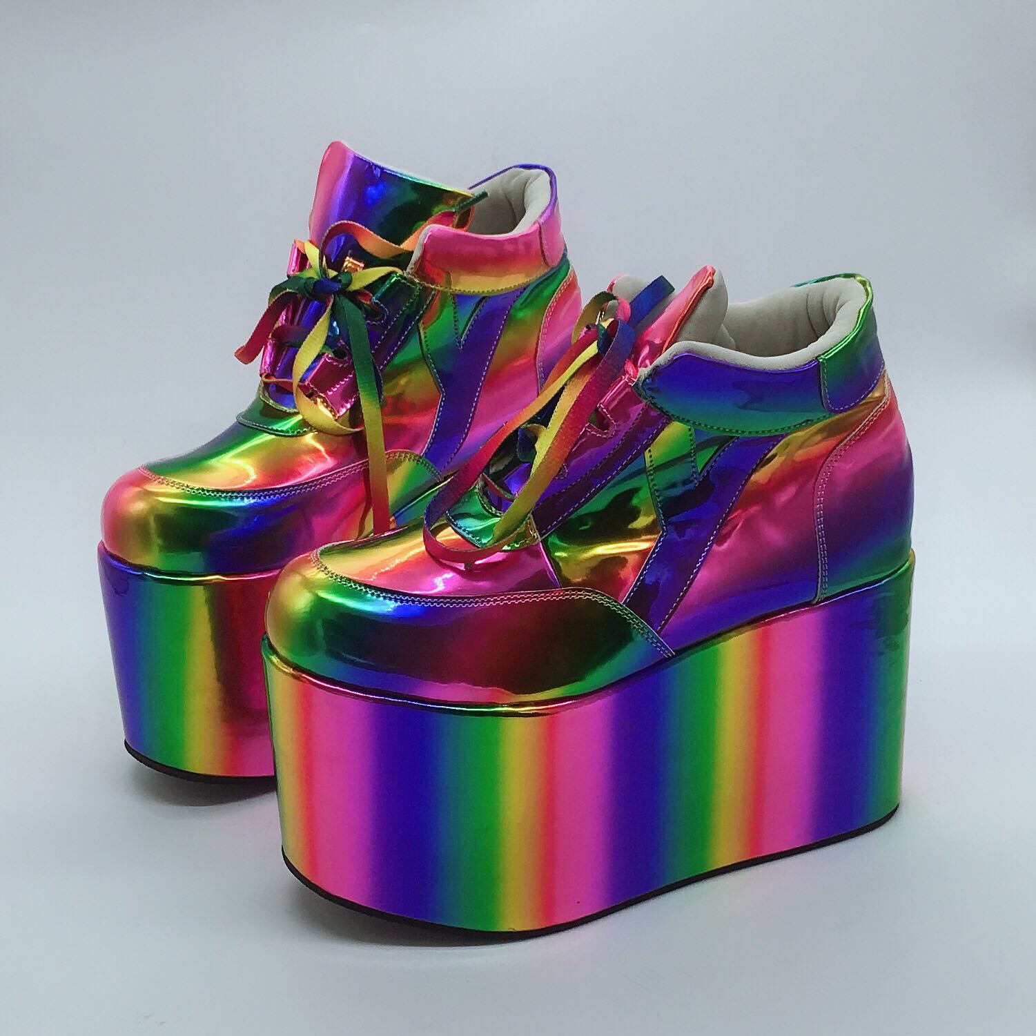 Pair of rainbow platform shoes on a light gray background