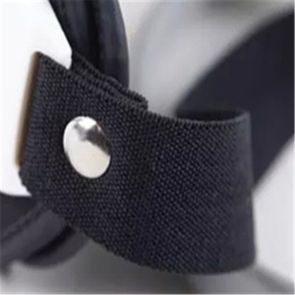 Close-up of a black strap with a silver button on a blurred background