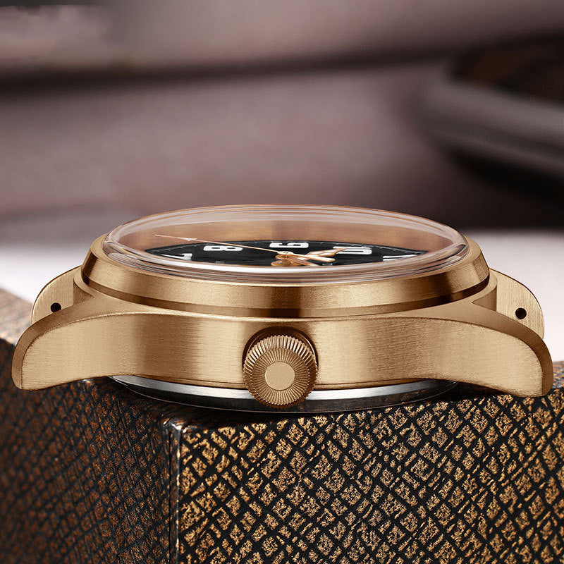Close-up of a bronze watch with a textured brown strap on a blurred background