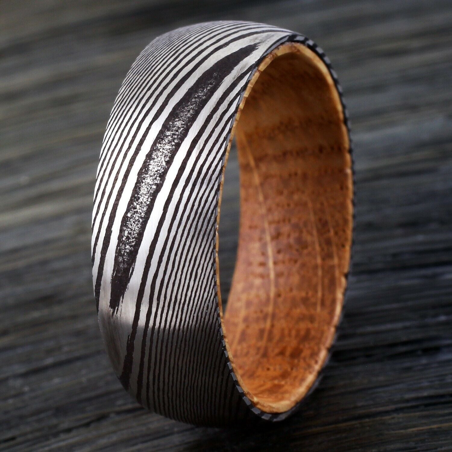 Wooden bracelet with black and white pattern on a wooden surface