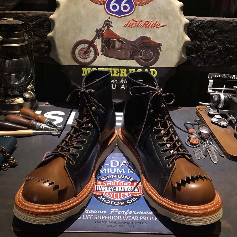Brown leather boots with a motorcycle-themed background featuring Route 66 and Harley-Davidson branding.
