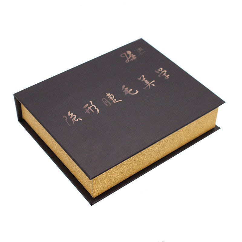 Black and gold box with engraved text on a white background