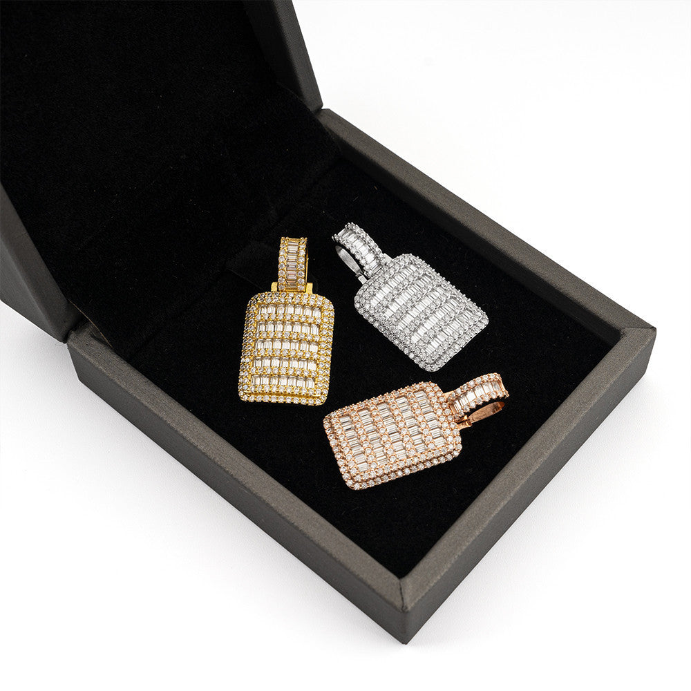 Three diamond-encrusted bottle-shaped pendants in gold, silver, and rose gold on a black box.